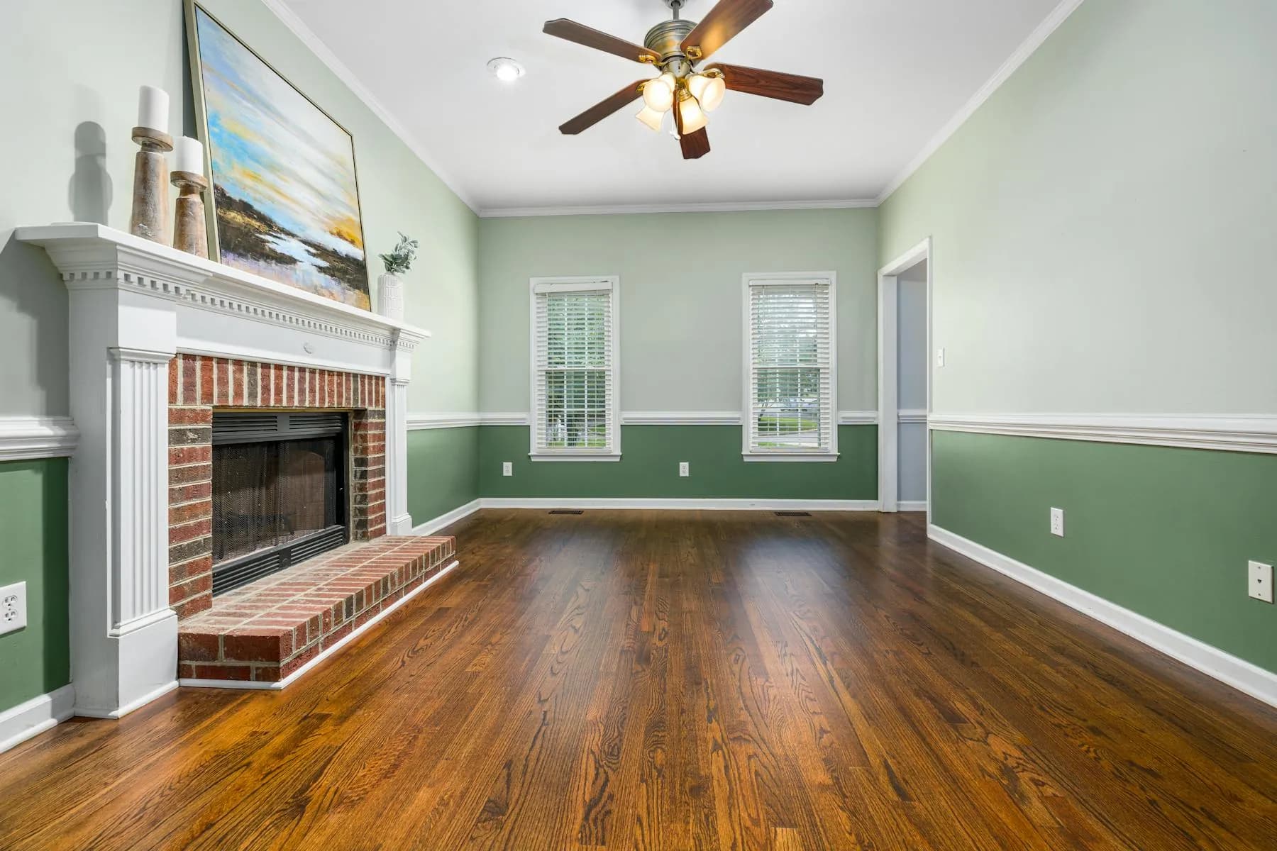 Freshly painted modern living room with soft blue accent wall and dark hardwood floors.