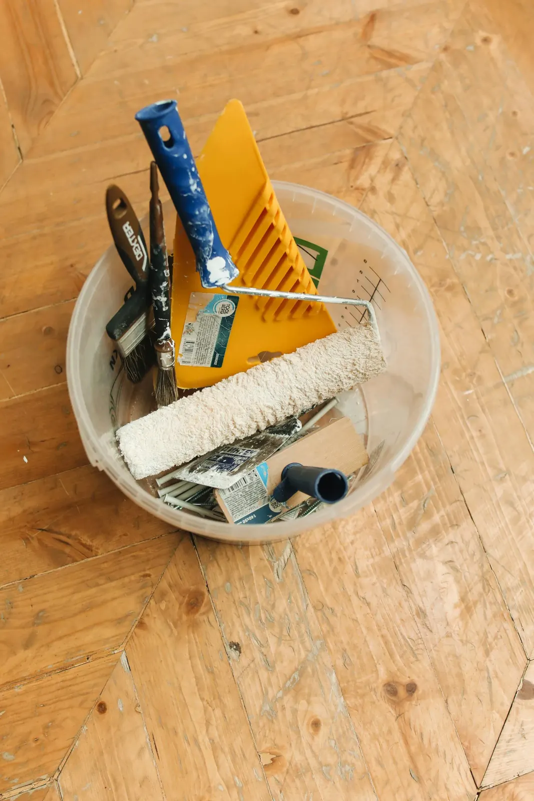 Painting tools organized on a wood floor, ready for project planning and quote review.